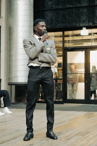 a man in a suit standing in front of a building