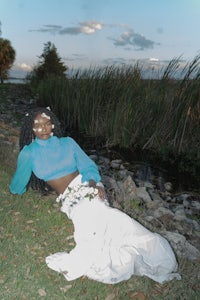 a woman in a white dress laying on the grass