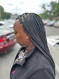 a woman with braided hair in a parking lot