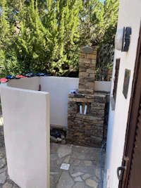 an outdoor shower with a stone wall