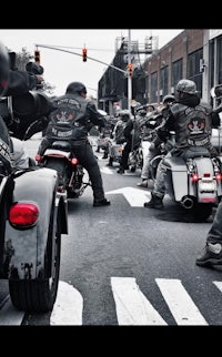 a group of motorcycle riders riding down the street