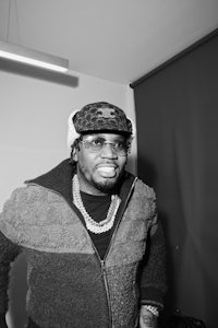 a black and white photo of a man wearing glasses and a sweater