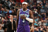 a man in a purple uniform standing on a court