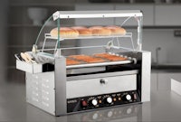 a hot dog grill with buns on top of it
