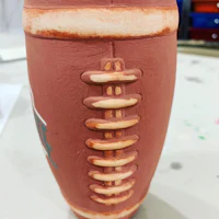 a clay pot with a football on it