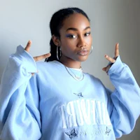a woman wearing a blue sweatshirt posing for the camera
