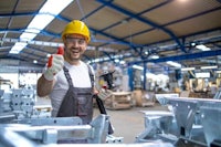 a worker giving a thumbs up in a factory
