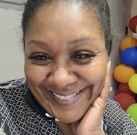 a woman smiling in front of colorful balloons