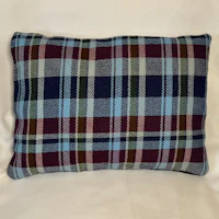 a plaid pillow on a white background