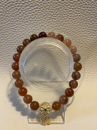 a brown beaded bracelet on a clear surface