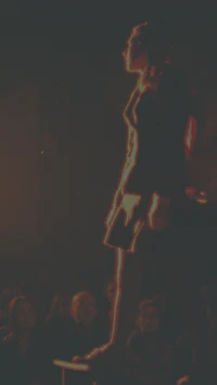 a woman is standing on a stage in front of a crowd