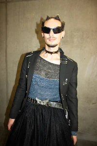 a man in a black jacket and black skirt