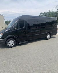 a black mercedes sprinter bus parked on the side of the road