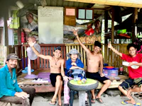 a group of people posing in front of a hut