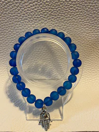 a blue glass bead bracelet with a silver charm