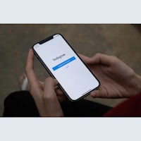 a woman holding an iphone with the instagram app on it
