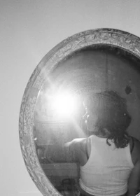 a black and white photo of a woman in a mirror