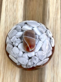 a white and brown stone bowl on a wooden table
