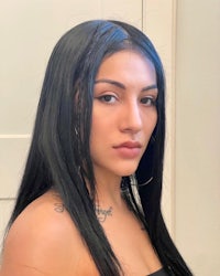 a woman with long black hair posing for a photo