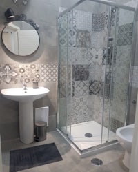 a bathroom with a glass shower stall and sink