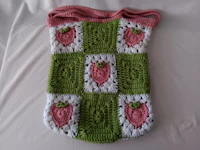 a crocheted bag with strawberries on it