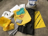 the contents of a hazard kit are laid out on a concrete floor