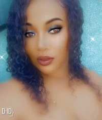 a woman with blue curly hair posing for a photo
