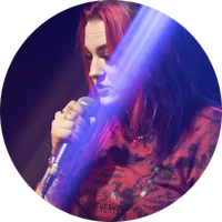 a woman with red hair singing into a microphone