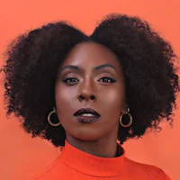 a black woman with a curly afro posing for a photo