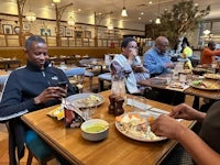 a group of people sitting at a table eating food