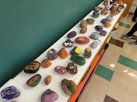 a group of people standing in front of a table full of rocks
