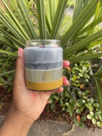 a person holding a candle in front of a palm tree