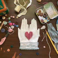 a table full of buttons, buttons, and a heart shaped glove