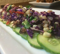 a plate of slaw and cucumbers on a white plate