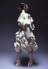 a woman wearing a white dress with ruffles