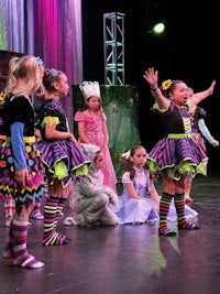 a group of children dressed up in costumes on a stage