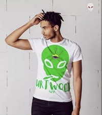 a man wearing a white t - shirt with a green alien on it