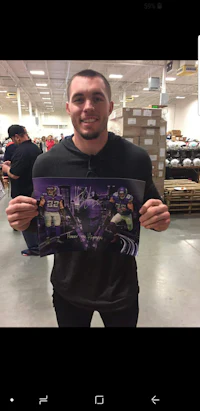 a man holding up a poster in a store