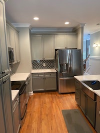 a kitchen with gray cabinets and stainless steel appliances