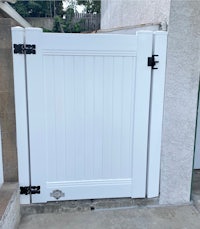 a white gate with a black handle on it
