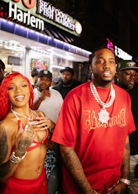 a group of people standing in front of a neon sign