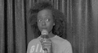 a black and white photo of a woman holding a microphone