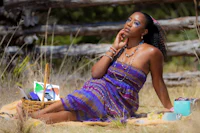 a woman in a purple dress sitting in the grass