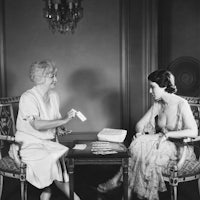 two women sitting at a table playing cards