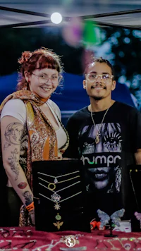 a man and woman standing next to a table full of jewelry