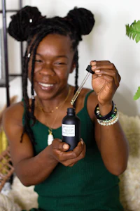 a woman holding a bottle of essential oil