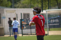a man in a red shirt is holding a soccer ball