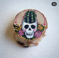 a piece of wood with a skull and cactus on it