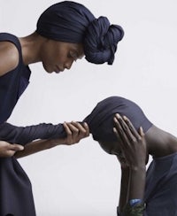 a woman is helping another woman put on a turban