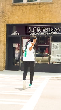 a woman crossing the street in front of a store